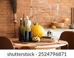 Stylish kitchen with dining table decorated for Halloween celebration