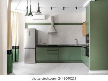 Stylish kitchen with green furniture . Minimalistic kitchen with equipment in a modern apartment . - Powered by Shutterstock