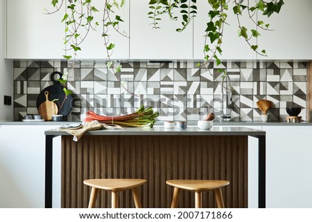 Stylish kitchen interior design with dining space. Workspace with kitchen accessories on the back ground. Creative walls. Minimalistic style an plant love concept. 
