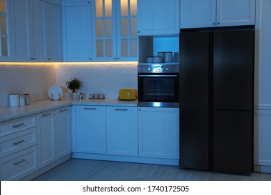 Stylish Kitchen Interior With Modern Refrigerator At Night