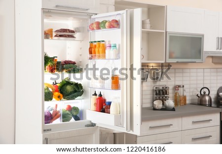 Stylish kitchen interior with refrigerator full of products