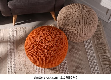 Stylish knitted poufs in room. Home design