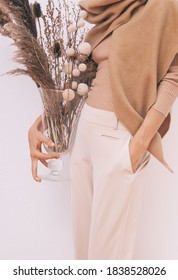 Stylish Lady In Beige Outfit With Flowers Decor.  Details Of Everyday Look. Trendy Minimalistic Style. Beige Aesthetics. Fashion Look Book. Warm Fall Winter Seasons Concept