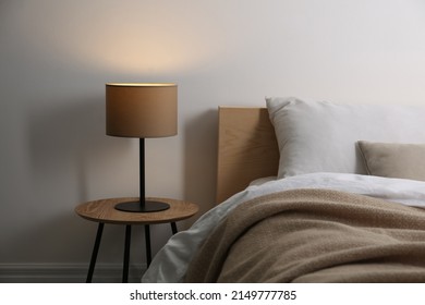 Stylish lamp on table near bed indoors - Powered by Shutterstock