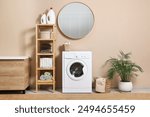 Stylish laundry room interior with washing machine, furniture and houseplant