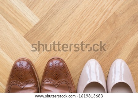 stylish leather shoes of a man and of a woman on wooden floor, wedding shoes for him and her