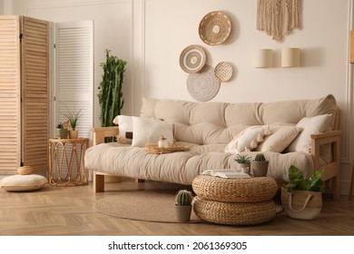 Stylish living room interior with comfortable wooden sofa and beautiful houseplants