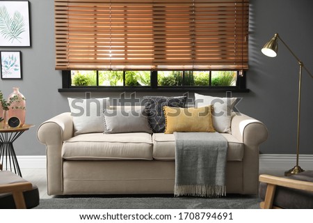 Stylish living room interior with comfortable sofa near window