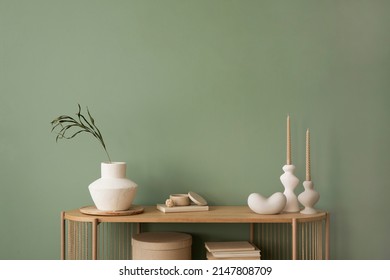 Stylish living room interior design wooden chest of drawers, beige vase and creative home accessories. Sage green wall. Copy space. Template.  - Shutterstock ID 2147808709