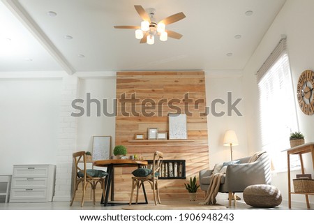 Stylish living room interior with modern ceiling fan, low angle view