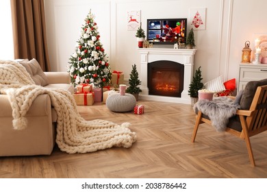 Stylish Living Room Interior With TV Set, Christmas Tree And Fireplace