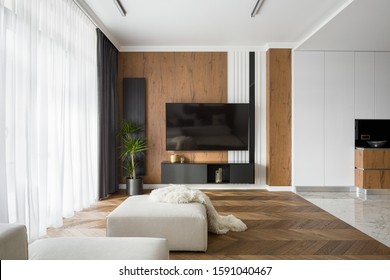 Stylish Living Room With Wooden Wall And Floor And Big Tv Screen Open To Kitchen With Marble Floors