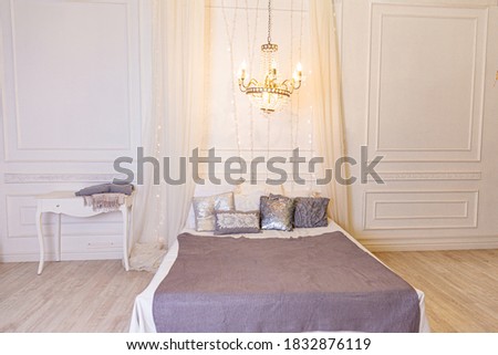 Stylish loft bedroom interior. Spacious design apartment in baroque style with light walls elegant furniture king size big bed. Beautiful luxury classic white bright clean interior bedroom