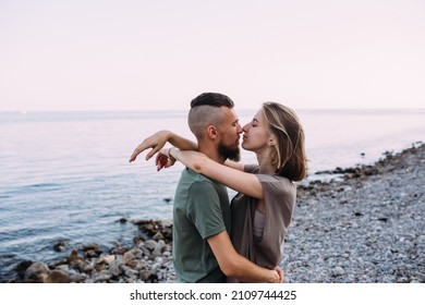 Stylish lovely couple walking and hugging by the sea enjoying time together
