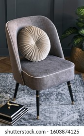 Stylish And Luxury Composition Of Design Gray Armchair With Books, Sculpture, Plant In Gold Pot And Elegant Accessories. Template. Interior Design. Modern Home Staging. Close Up. 