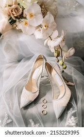 Stylish luxury shoes with lace floral pattern . Modern wedding shoes on tulle in soft morning light. Bridal morning preparations and boudoir. Flat lay 