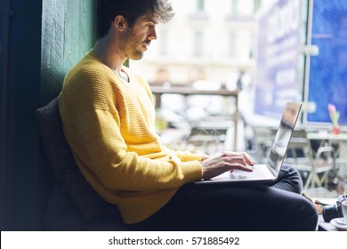 Stylish male freelancer working on new startup project making internet researchers analyzing data using laptop computer and wireless connection to 4G internet in city cafe with free wireless zone - Shutterstock ID 571885492