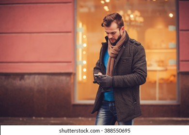 Stylish Man In A Coat With A Smartphone In The City. Traveling