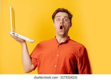 Stylish Man In Orange Shirt With Laptop Computer On Yellow Background