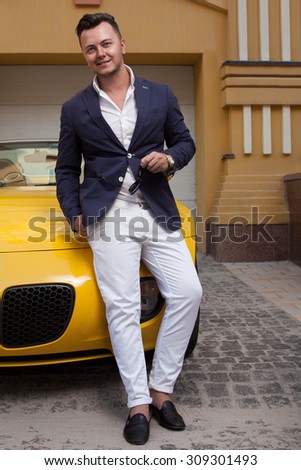 Stylish man posing with convertible sportcar
