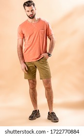 Stylish Man Posing In Shorts And Summer T-shirt On Beige