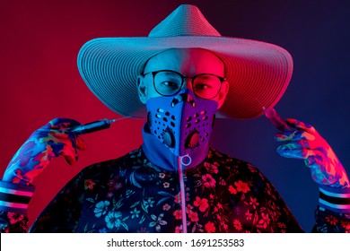 Stylish Man Wearing Medical Respirator Mas, Glasses, Hat And Gloves And Holding Two Syringes With Coronavirus Covid 19  Blood Test. Concept Of Mad Doctor, Inventor Of Corona Virus