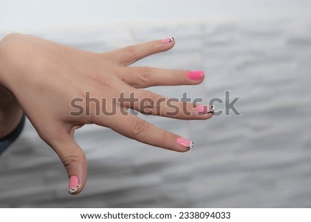 
Stylish manicure in color Barbie pink shades of gel polish on short nails. Concept of Barbie the movie.