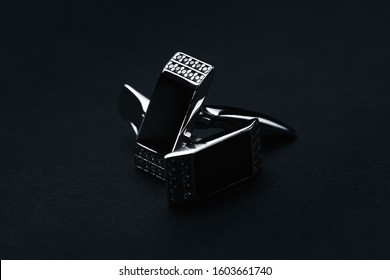 Stylish men's stainless steel cufflinks with black stone on a dark background. Men's fashion accessories. Black background. Close up