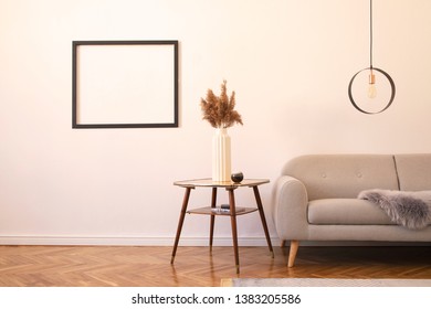 Stylish minimalistic living room with design grey sofa, geometric lamp, retro table, flwoers, blanket and elegant accessories Mock up posters frame on the white walls. Minimalistic home decor. 