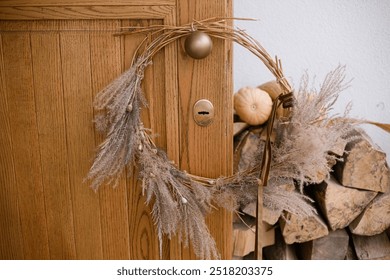 Stylish modern autumn wreath on wooden doors. Fall decor of farm house entrance. Rustic wreath with dried grass, herbs and ribbon. Thanksgiving and Halloween - Powered by Shutterstock