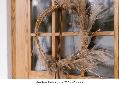 Stylish modern autumn wreath on wooden doors. Fall decor of farm house entrance. Rustic wreath with dried grass, herbs and ribbon. Thanksgiving and Halloween - Powered by Shutterstock