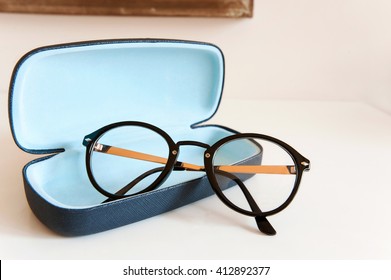 Stylish modern fashionable elegant black eyeglasses in blue leather case. Indoors horizontal close-up colorful image.