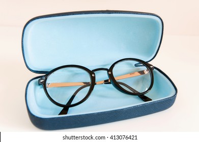 Stylish modern fashionable elegant black eyeglasses in blue leather case. Indoors horizontal close-up colorful image.