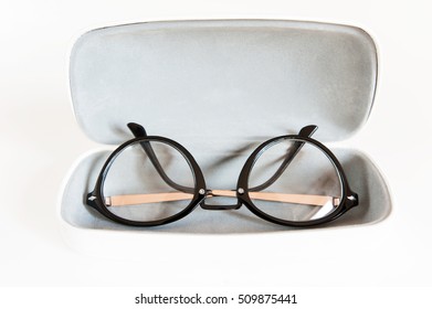 Stylish modern fashionable elegant black eyeglasses in white leather case. Indoors horizontal close-up image.