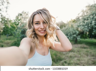 Stylish modern girl taking a selfie out in the park.