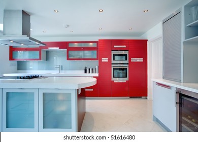 Stylish Modern Kitchen With Red Cupboards And Drawer And Stainless Steel Appliances