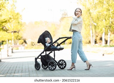 Stylish Mom With Stroller Talking On The Phone In Autumn Park