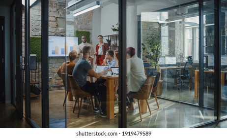 Stylish Office Conference Room Meeting: Female and Male CEO Deliver Speech to a Diverse Group of Multi-Ethnic Professionals. Executives Report about Data Analysis, Marketing Strategy for Social Media - Powered by Shutterstock