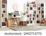 Stylish office with workplace, modern computer, chair and bookcase