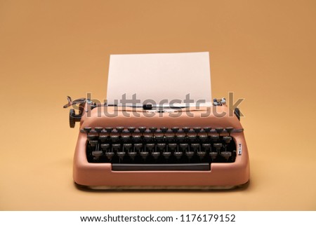 Stylish old typewriter with a paper sheet on the yellow background in the studio. Closeup. Horizontal.