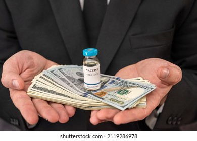 A Stylish Older Man In A Suit Carries The Vaccine In A Jar And Dollars For It. Vaccination Concept For Big Money