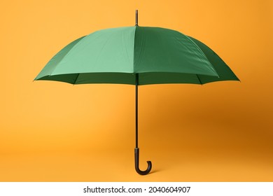 Stylish open green umbrella on yellow background - Shutterstock ID 2040604907