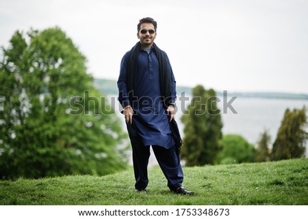 Stylish pakistani indian muslim arabic man in kurta dhoti suit and sunglasses.