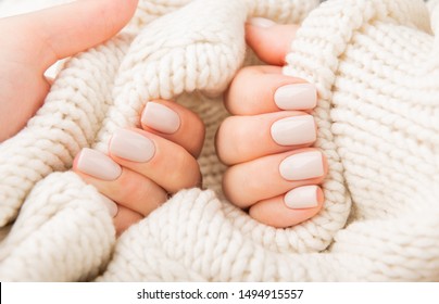 Stylish pastel beige Nails holding knitted wool material