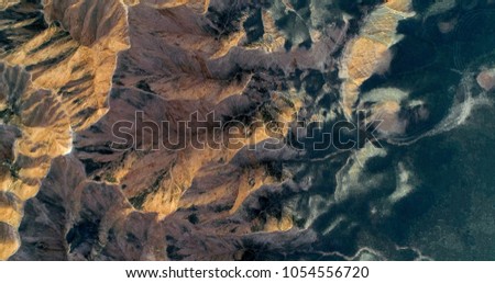Stylish pattern created by nature. Aerial view on sandstone mountains partially covered by vegetation creating a unique, colorful landscape. Zhangye Danxia National Park, China.