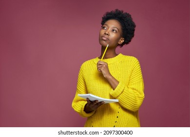 Stylish pensive african american girl pondering idea to write into notebook, thinking over business plan, to-do list - Shutterstock ID 2097300400