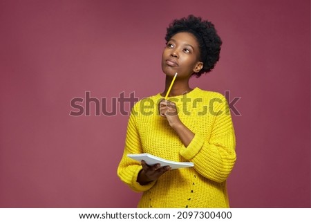 Stylish pensive african american girl pondering idea to write into notebook, thinking over business plan, to-do list