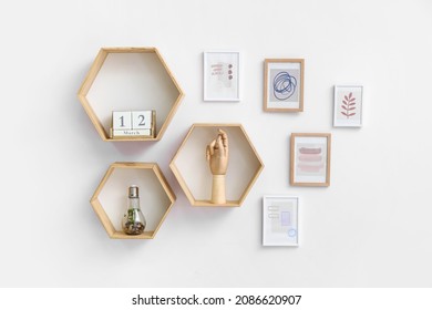 Stylish Pictures And Shelves With Decor Hanging On Light Wall