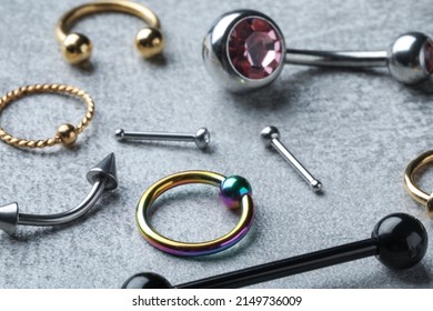 Stylish piercing jewelry on light grey table, closeup