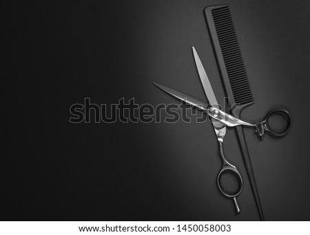 Stylish professional barber scissors, hair cutting shears on black background. Hairdresser salon equipment concept, hairdressing set. Haircut accessories. Copy space image, flat lay mockup